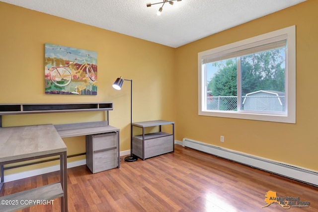 3306 E 19th Ct, Anchorage, AK 99508 - office area with a baseboard heating unit, wood finished floors, and a textured ceiling