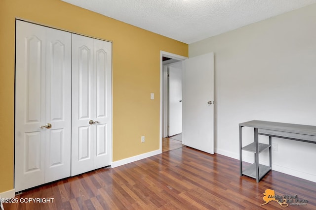 3306 E 19th Ct, Anchorage, AK 99508 - unfurnished bedroom with wood finished floors, a closet, and a textured ceiling