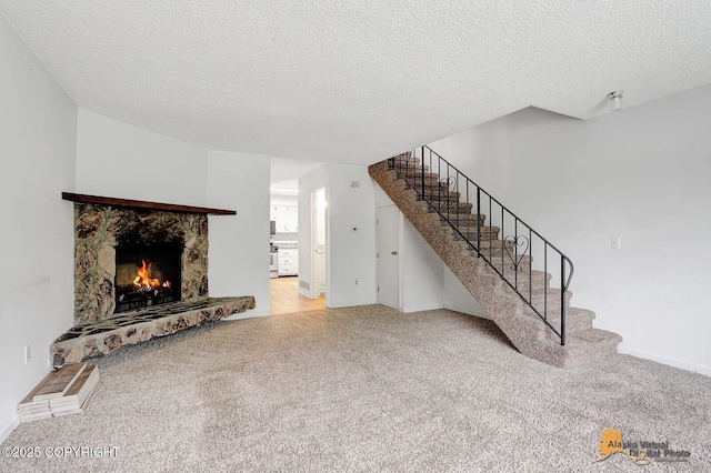 791 N Yakima St, Wasilla, AK 99654 - unfurnished living room featuring carpet flooring, stairs, a textured ceiling, and a fireplace