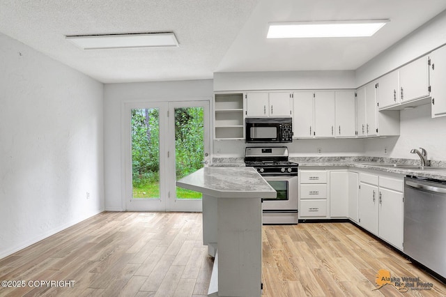 791 N Yakima St, Wasilla, AK 99654 - kitchen with stainless steel appliances, open shelves, light countertops, white cabinets, and a textured ceiling