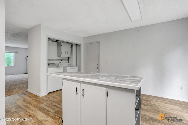 791 N Yakima St, Wasilla, AK 99654 - kitchen featuring washer and dryer, light wood-style floors, light countertops, a textured ceiling, and a center island