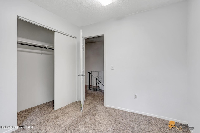 791 N Yakima St, Wasilla, AK 99654 - unfurnished bedroom featuring carpet flooring, a closet, and a textured ceiling