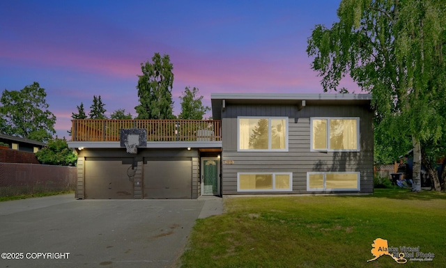 1915 Stanford Dr, Anchorage, AK 99508 - view of front facade with concrete driveway, a front yard, a garage, and a balcony
