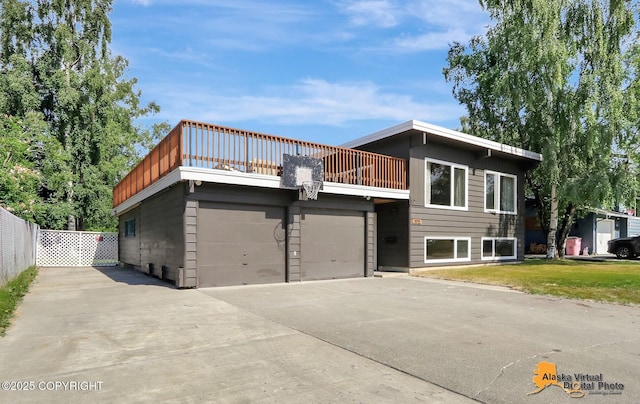 1915 Stanford Dr, Anchorage, AK 99508 - view of front of house featuring a balcony, driveway, and an attached garage