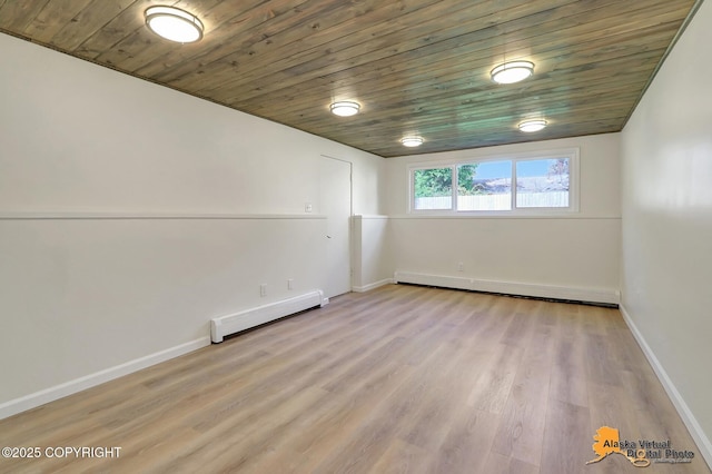 1915 Stanford Dr, Anchorage, AK 99508 - spare room featuring a baseboard radiator, light wood finished floors, and wood ceiling