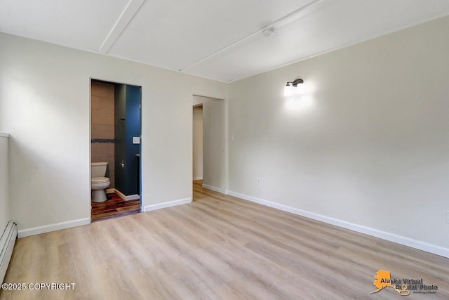 1915 Stanford Dr, Anchorage, AK 99508 - unfurnished room featuring wood finished floors and a baseboard heating unit