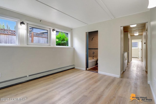 1915 Stanford Dr, Anchorage, AK 99508 - unfurnished bedroom with baseboard heating, multiple windows, light wood-style flooring, and connected bathroom