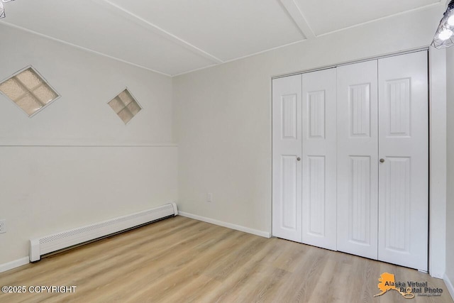 1915 Stanford Dr, Anchorage, AK 99508 - unfurnished bedroom featuring a baseboard radiator, wood finished floors, and a closet