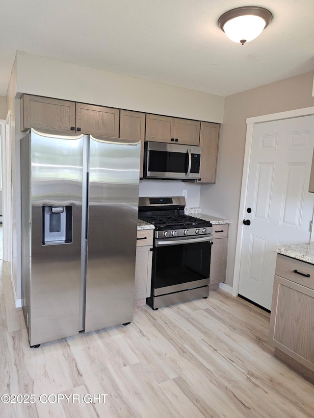 150 S Leibrock St, Soldotna, AK 99669 - kitchen featuring stainless steel appliances, light wood-style floors, and light stone counters