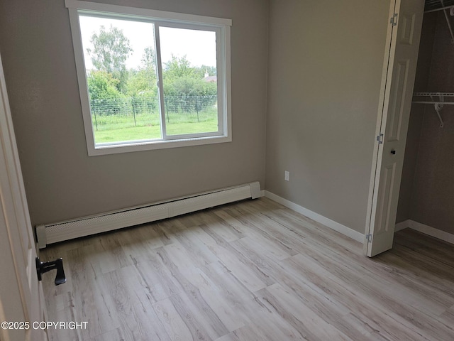 150 S Leibrock St, Soldotna, AK 99669 - unfurnished bedroom featuring a baseboard radiator, light wood-type flooring, and a closet