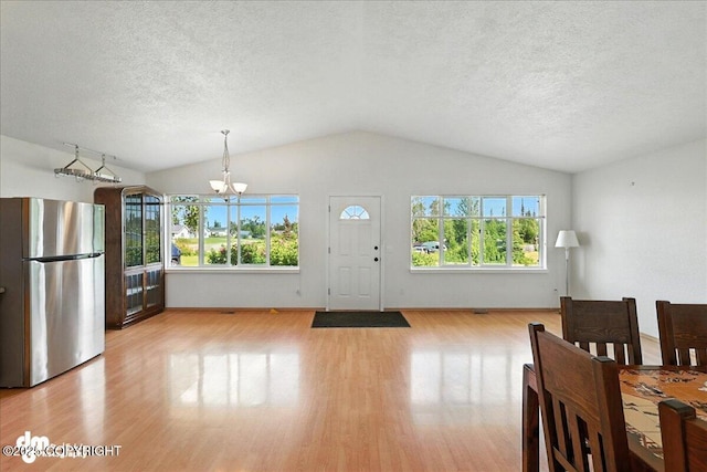 46640 Jo Ave, Kenai, AK 99611 - foyer entrance with a chandelier, light wood-style floors, lofted ceiling, plenty of natural light, and a textured ceiling