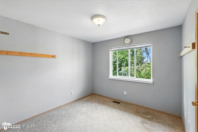 46640 Jo Ave, Kenai, AK 99611 - carpeted empty room with baseboards and a textured ceiling