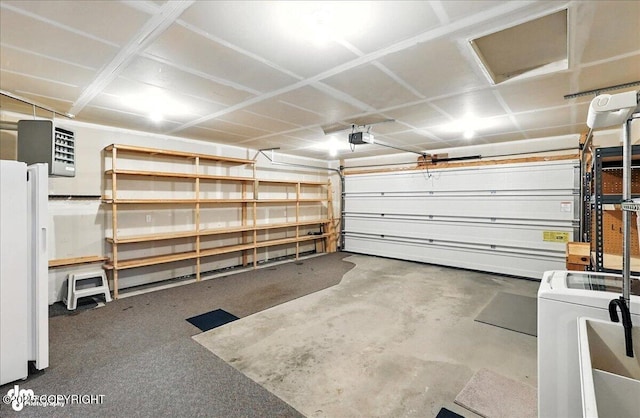 46640 Jo Ave, Kenai, AK 99611 - garage featuring a garage door opener, washer / clothes dryer, freestanding refrigerator, and a heating unit