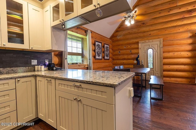 2415 Afognak Ave, Seward, AK 99664 - kitchen featuring log walls, a peninsula, ceiling fan, dark wood-type flooring, and light stone counters