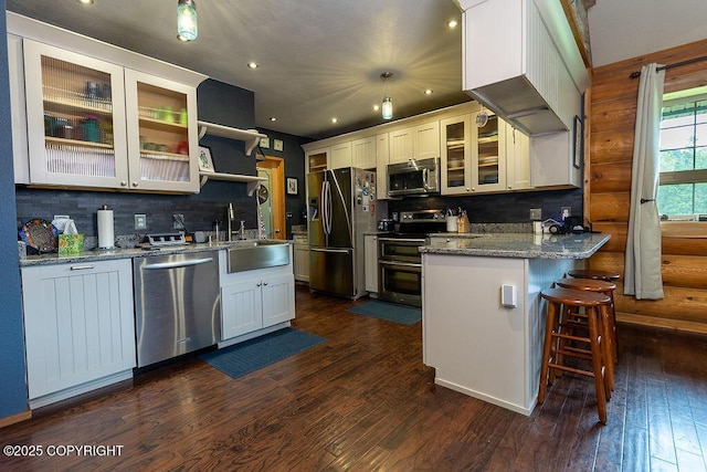 2415 Afognak Ave, Seward, AK 99664 - kitchen featuring appliances with stainless steel finishes, a peninsula, backsplash, dark wood-style flooring, and recessed lighting