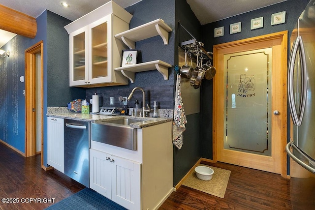 2415 Afognak Ave, Seward, AK 99664 - kitchen with dark wood finished floors, appliances with stainless steel finishes, light stone counters, glass insert cabinets, and white cabinets