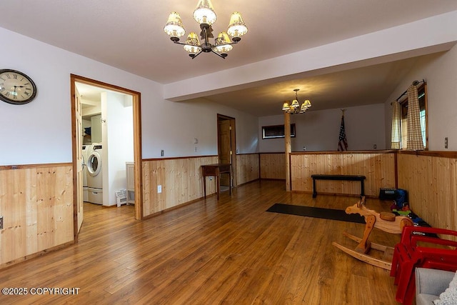 2415 Afognak Ave, Seward, AK 99664 - living area with a chandelier, a wainscoted wall, wood walls, wood finished floors, and washer / dryer