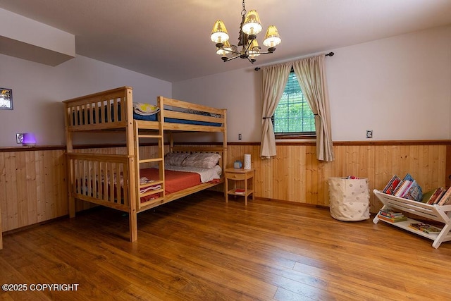 2415 Afognak Ave, Seward, AK 99664 - bedroom with a wainscoted wall, a chandelier, wood finished floors, and wooden walls