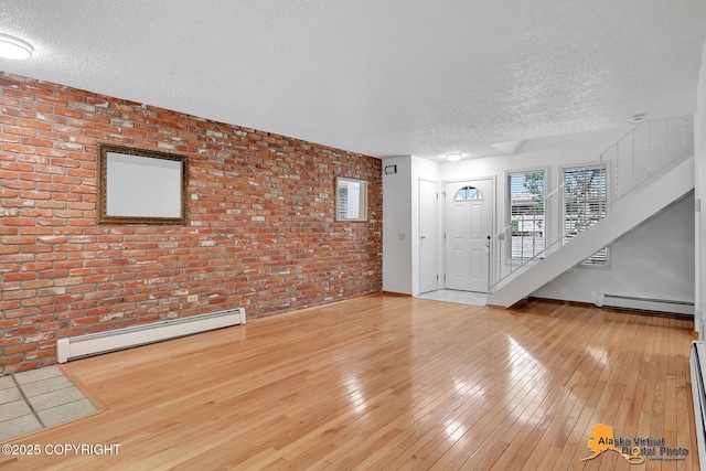 3958 Reka Dr Unit A-2, Anchorage, AK 99508 - unfurnished living room with brick wall, a textured ceiling, a baseboard radiator, and light wood-style floors