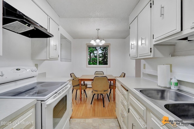 3958 Reka Dr Unit A-2, Anchorage, AK 99508 - kitchen featuring electric range, range hood, light countertops, a textured ceiling, and white cabinets