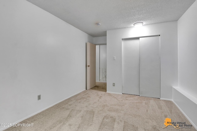 3958 Reka Dr Unit A-2, Anchorage, AK 99508 - unfurnished bedroom featuring carpet floors, a closet, and a textured ceiling
