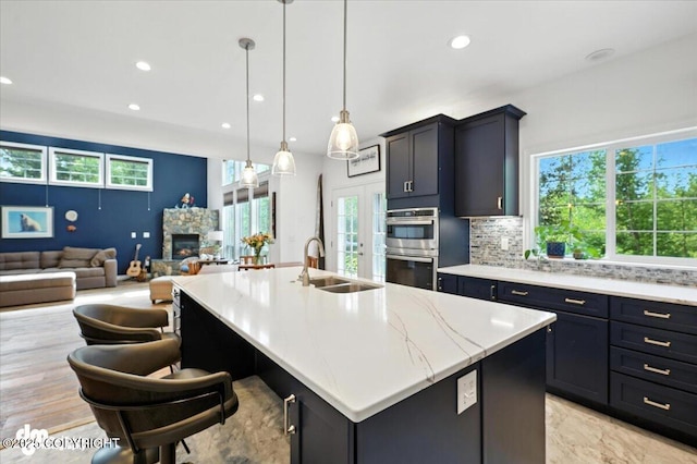 2436 N Hope Cir, Palmer, AK 99645 - kitchen featuring stainless steel double oven, open floor plan, an island with sink, tasteful backsplash, and recessed lighting