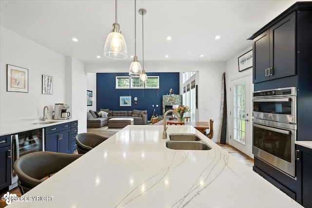 2436 N Hope Cir, Palmer, AK 99645 - kitchen with double oven, open floor plan, light stone counters, beverage cooler, and pendant lighting
