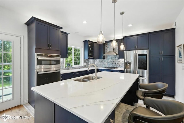 2436 N Hope Cir, Palmer, AK 99645 - kitchen featuring appliances with stainless steel finishes, wall chimney range hood, backsplash, light stone countertops, and pendant lighting