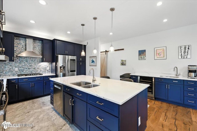 2436 N Hope Cir, Palmer, AK 99645 - kitchen with wine cooler, wall chimney range hood, appliances with stainless steel finishes, a barn door, and blue cabinets