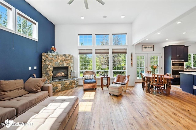 2436 N Hope Cir, Palmer, AK 99645 - living area featuring a ceiling fan, light wood-style floors, a fireplace, recessed lighting, and a towering ceiling