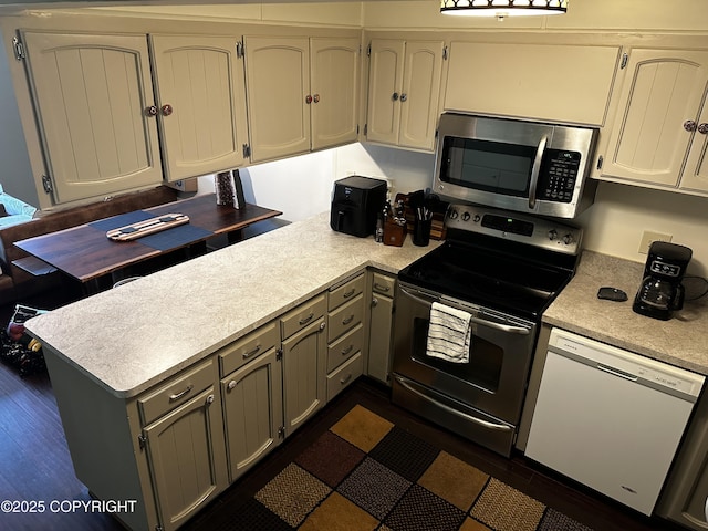 2703 David St, Juneau, AK 99801 - kitchen featuring appliances with stainless steel finishes, a peninsula, light countertops, and gray cabinetry