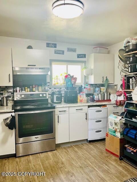 515 Maple Ave, Kodiak, AK 99615 - kitchen featuring stainless steel range with electric cooktop, under cabinet range hood, backsplash, white cabinets, and light countertops