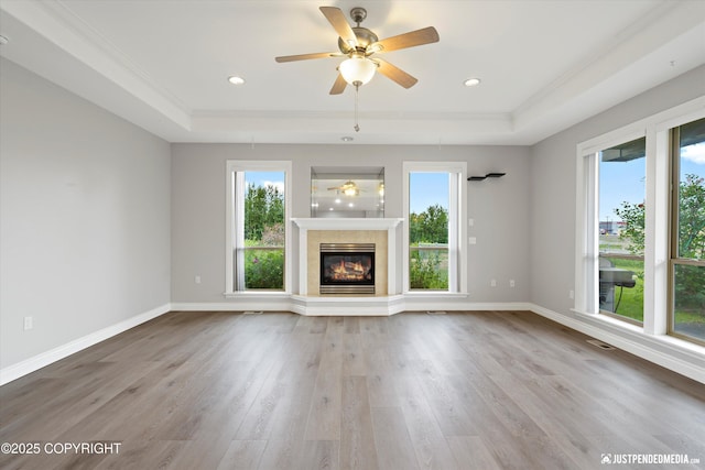 3827 E Country Field Cir, Wasilla, AK 99654 - unfurnished living room featuring a tray ceiling, healthy amount of natural light, crown molding, wood finished floors, and ceiling fan