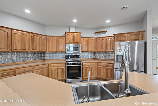 3827 E Country Field Cir, Wasilla, AK 99654 - kitchen with appliances with stainless steel finishes, backsplash, light countertops, brown cabinets, and recessed lighting