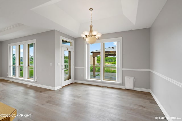 3827 E Country Field Cir, Wasilla, AK 99654 - unfurnished dining area featuring a tray ceiling, healthy amount of natural light, and light wood finished floors