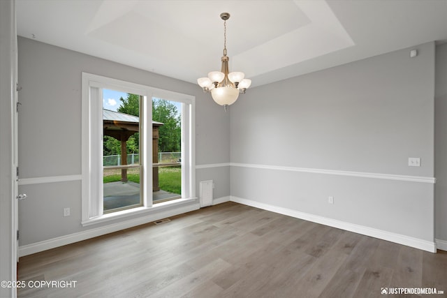 3827 E Country Field Cir, Wasilla, AK 99654 - unfurnished room featuring a chandelier, a tray ceiling, and wood finished floors