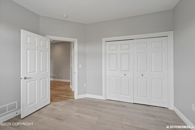 3827 E Country Field Cir, Wasilla, AK 99654 - unfurnished bedroom featuring light wood-style flooring and a closet