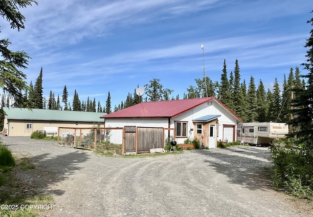 21635 Renault St, Kasilof, AK 99610 - view of front of home with a garage, a metal roof, and gravel driveway