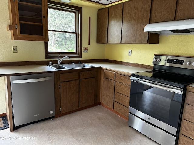 9238 Emily Way, Juneau, AK 99801 - kitchen featuring appliances with stainless steel finishes, under cabinet range hood, a textured wall, light countertops, and dark brown cabinetry