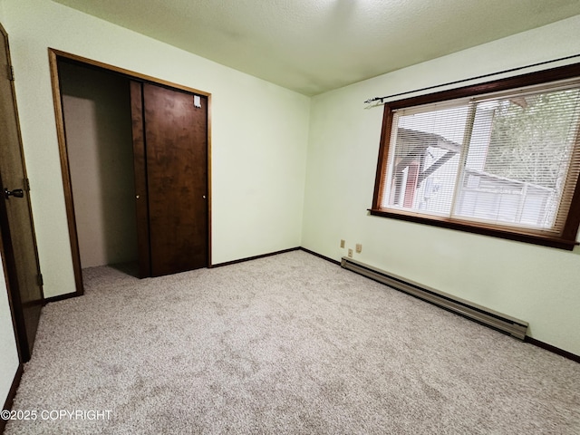 9238 Emily Way, Juneau, AK 99801 - unfurnished bedroom featuring baseboard heating, light carpet, and a closet