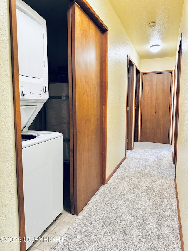 9238 Emily Way, Juneau, AK 99801 - washroom featuring stacked washer and clothes dryer, light carpet, a textured wall, and a textured ceiling