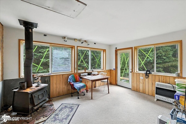 63735 Caribou Ln, Hope, AK 99605 - office featuring wooden walls, heating unit, a wood stove, wainscoting, and light colored carpet