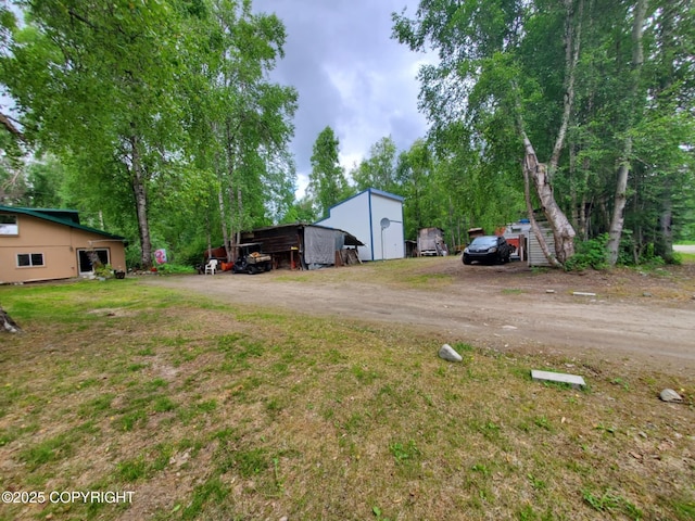 22120 S Easy St, Talkeetna, AK 99676 - view of yard featuring dirt driveway, an outdoor structure, and an outbuilding