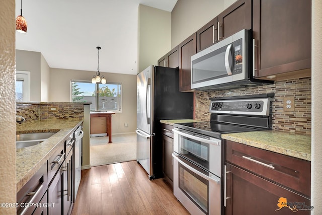 7612 Lumbis Ave # 4, Anchorage, AK 99518 - kitchen with stainless steel appliances, light wood-style floors, backsplash, dark brown cabinets, and decorative light fixtures