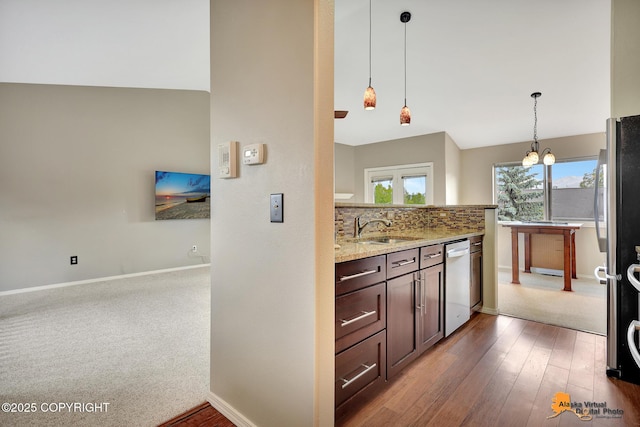 7612 Lumbis Ave # 4, Anchorage, AK 99518 - kitchen featuring appliances with stainless steel finishes, light stone countertops, decorative light fixtures, dark brown cabinets, and hardwood / wood-style floors