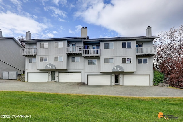 7612 Lumbis Ave # 4, Anchorage, AK 99518 - back of property with a chimney, an attached garage, a balcony, and driveway