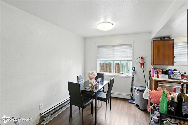 330 N Bliss St, Anchorage, AK 99508 - dining space with a baseboard heating unit, light wood-type flooring, and a baseboard radiator