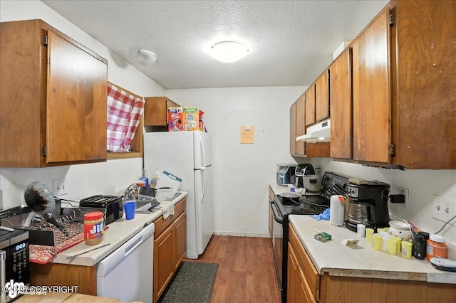 330 N Bliss St, Anchorage, AK 99508 - kitchen featuring white appliances, under cabinet range hood, light wood-type flooring, brown cabinetry, and a textured ceiling