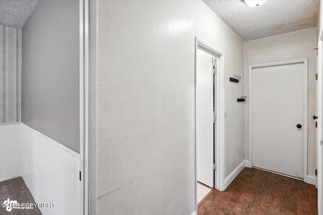 18723 N Lowrie Loop, Eagle River, AK 99577 - hall featuring a textured ceiling, wood finished floors, and a wainscoted wall