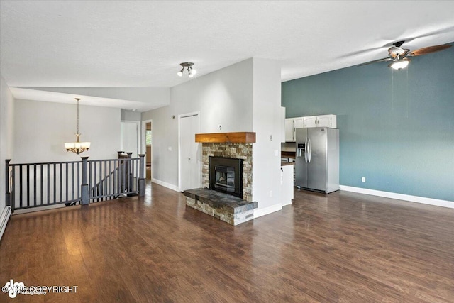18723 N Lowrie Loop, Eagle River, AK 99577 - unfurnished living room featuring a chandelier, dark wood finished floors, a ceiling fan, and a stone fireplace